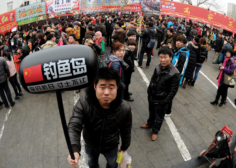 A man holding an inflatable sign declaring that the Diaoyu Islands are Chinese sovereign territory, location unknown. Source: ImagineChina