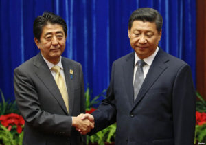 Abe and Xi shake hands at the APEC meeting in Beijing Photo: gdb.voanews.com